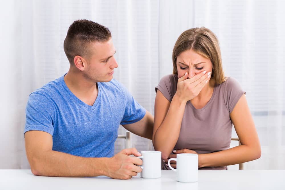 Husband is consoling his wife because she feel nausea.Morning sickness